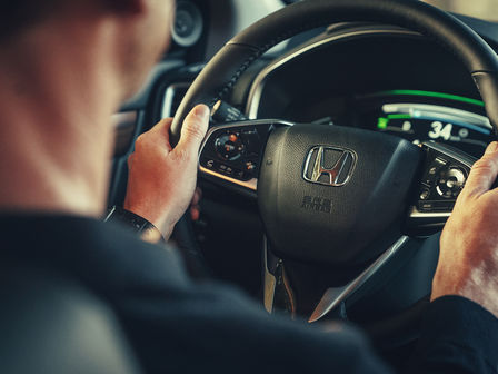 Detailný záber na model vo vozidle Honda CR-V Hybrid s volantom.