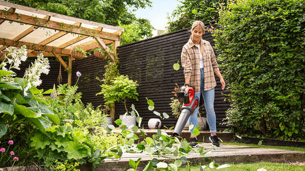 Žena používa akumulátorový fukár v záhrade