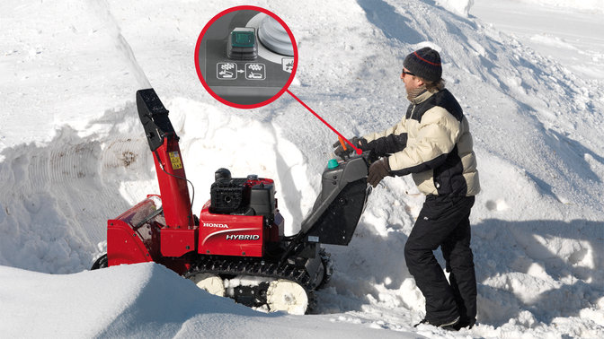 Snehová fréza Hybrid používaná modelom, zameranie na tlačidlo obnovenia nastavenia, na snehu.