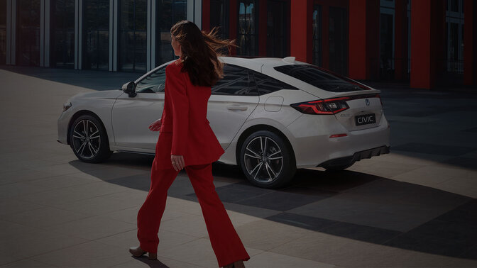Lady walking up to a Civic Hybrid