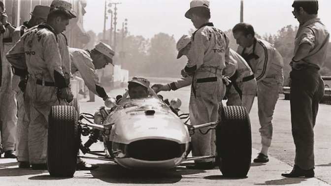 Automobil Honda Formula One zo šesťdesiatych rokov s pilotom a technikmi (záber spredu)
