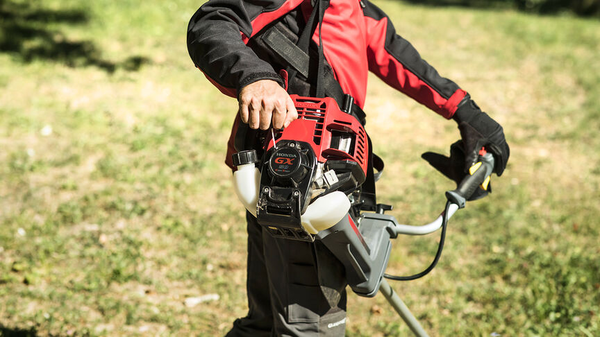 Figurant v lese s krovinorezom na chrbte.