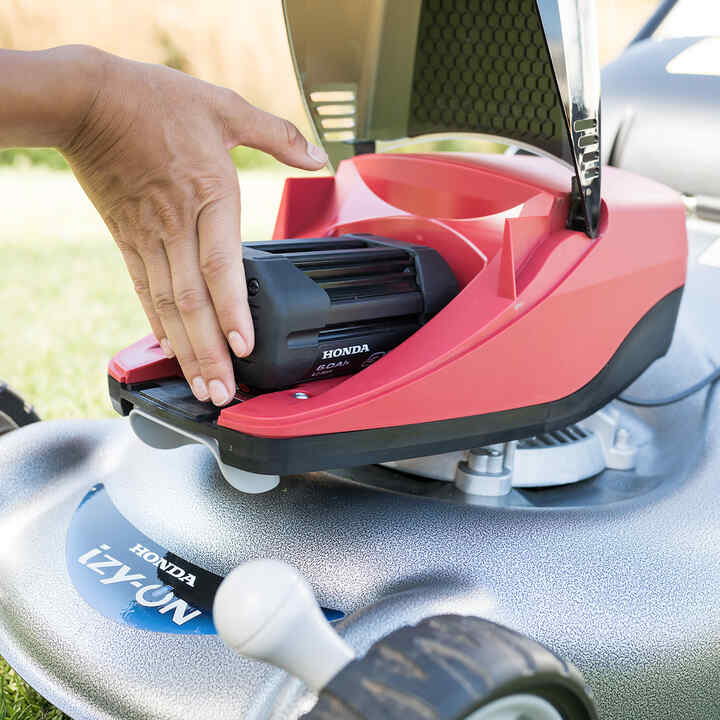 Muž pripája batériu do akumulátorového plotostrihu