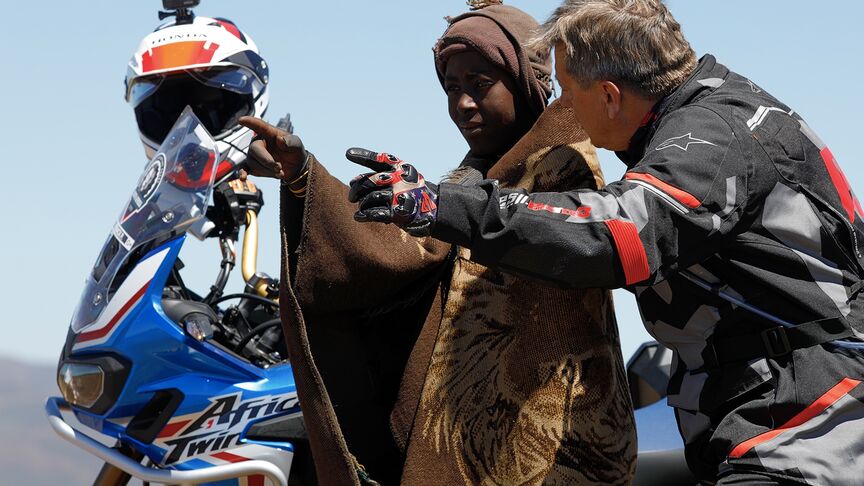 Motocyklový jazdec prechádzajúci náročným terénom Južnej Afriky.